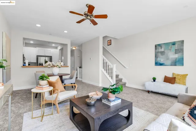 a living room with furniture kitchen view and a potted plant