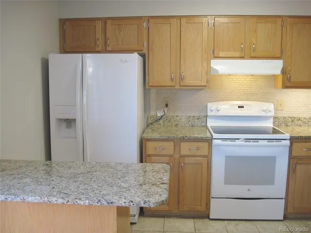 a kitchen with a stove refrigerator and cabinets