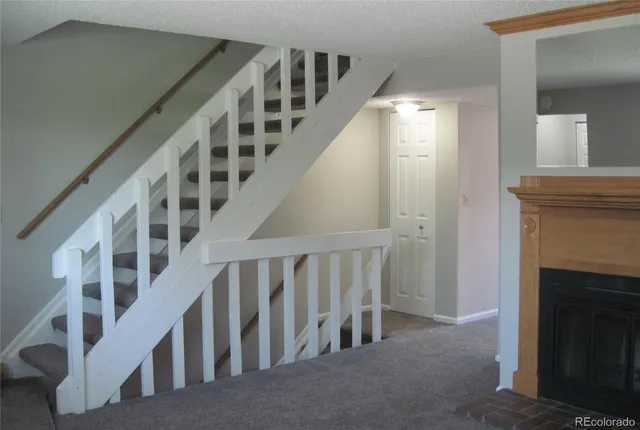 a view of staircase with railing and a fireplace