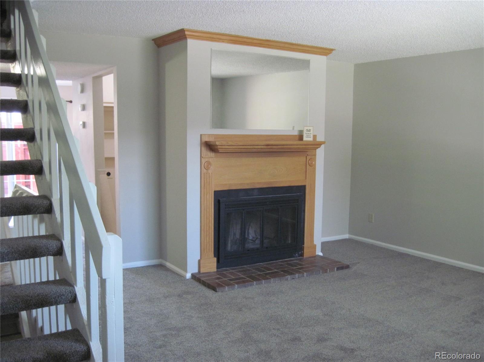 258 West Rockrimmon Boulevard, Unit F Colorado Springs, CO 80919 - Photo 4 of 41 a view of an empty room with stairs and a fireplace
