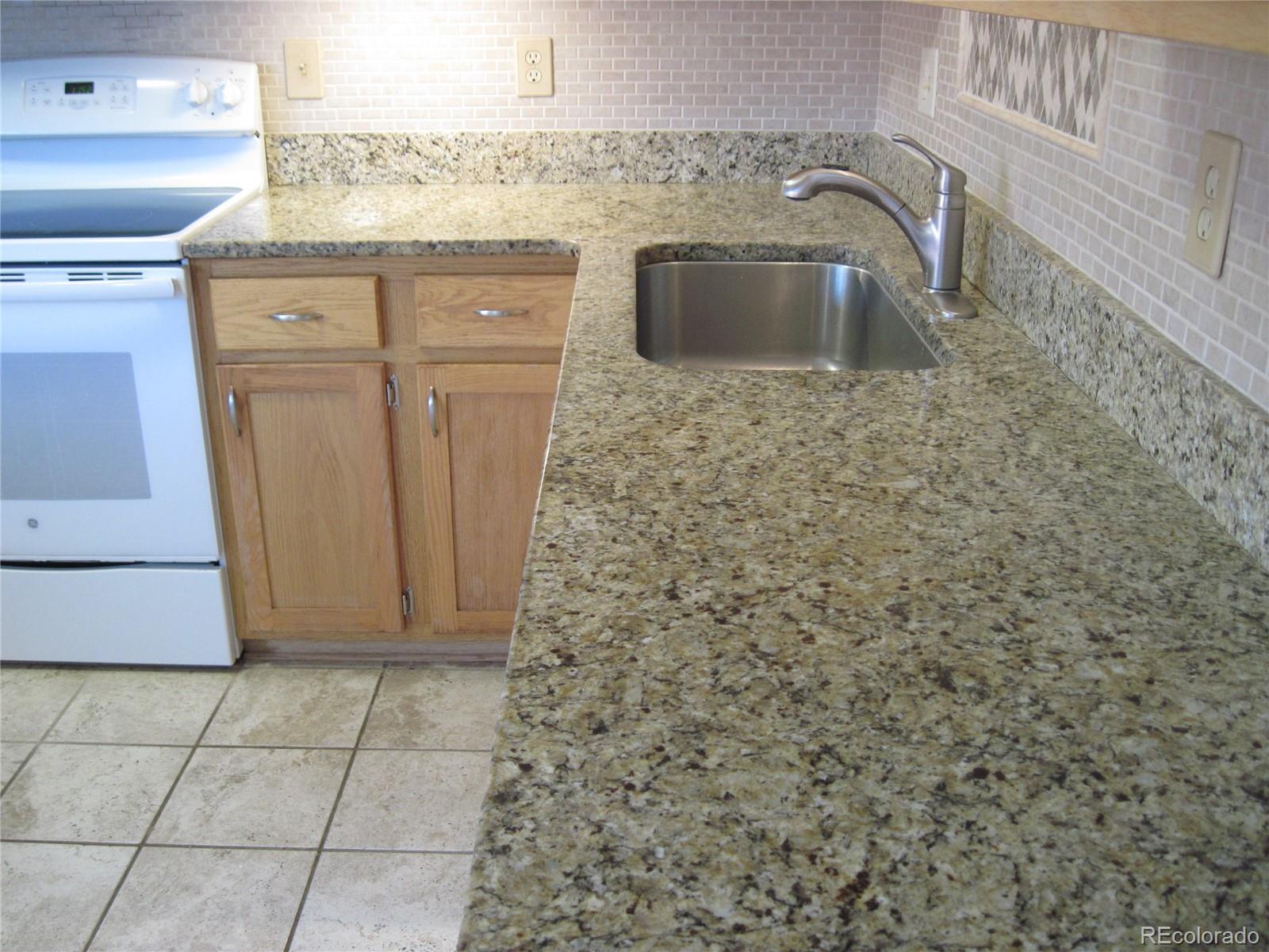 258 West Rockrimmon Boulevard, Unit F Colorado Springs, CO 80919 - Photo 8 of 41 a bathroom with a granite countertop sink a toilet and a mirror