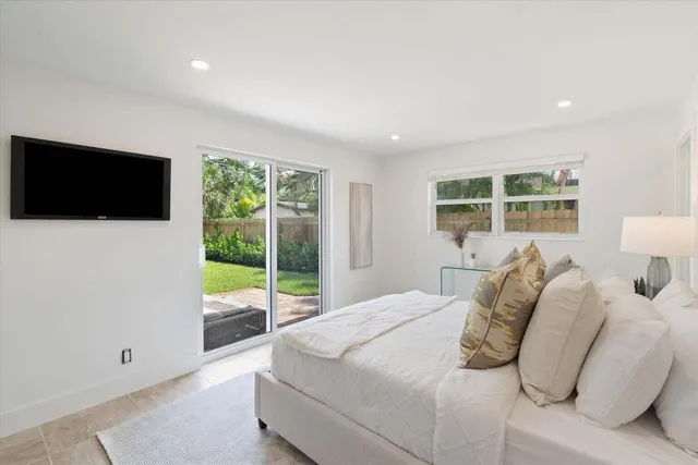 a bedroom with a large bed and a flat screen tv