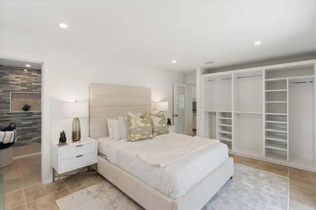 a large bedroom with a bed and a view of walk in closet