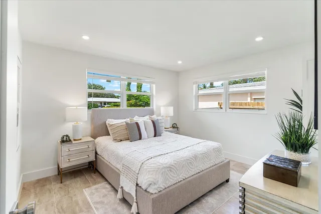 a bedroom with a large bed and a potted plant