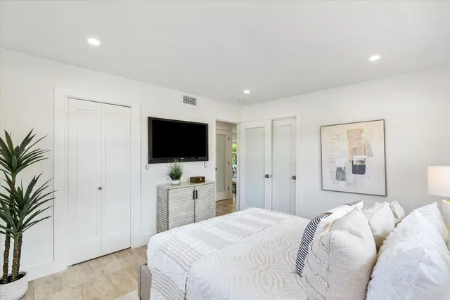 a bedroom with a bed and a flat screen tv