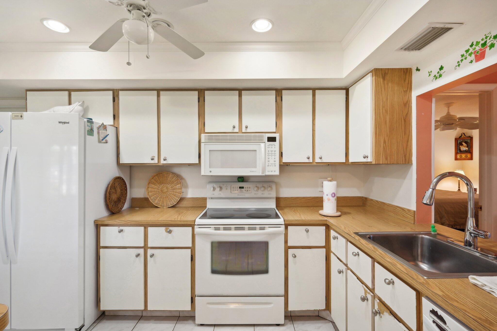 125 Wandering Trail, Unit TRL Jupiter, FL 33458 - Photo 11 of 22 a kitchen with a stove a sink and a refrigerator