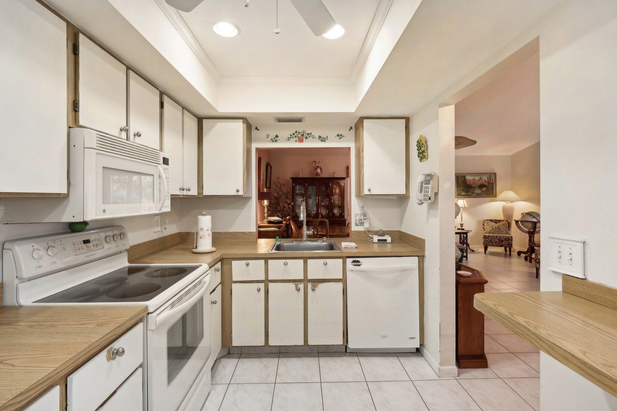 125 Wandering Trail, Unit TRL Jupiter, FL 33458 - Photo 12 of 22 a kitchen with a stove sink and cabinets