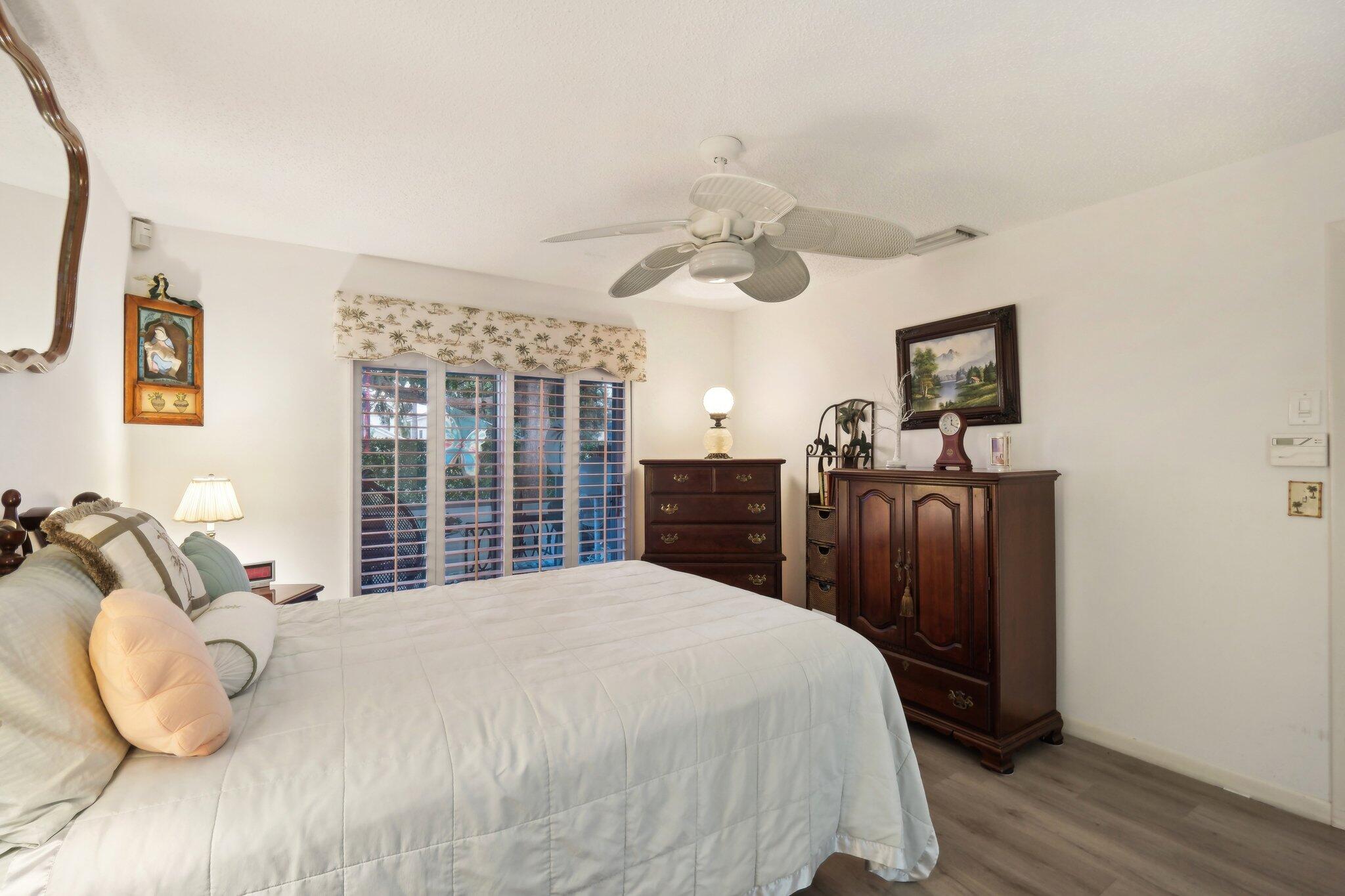 125 Wandering Trail, Unit TRL Jupiter, FL 33458 - Photo 15 of 22 a bedroom with a bed and wooden floor