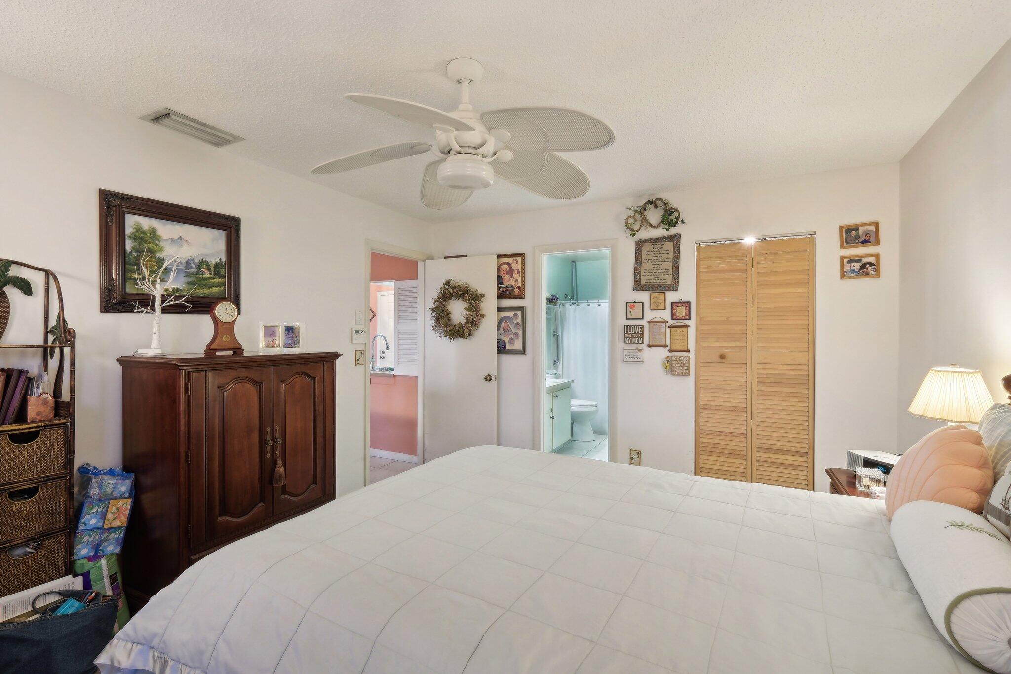 125 Wandering Trail, Unit TRL Jupiter, FL 33458 - Photo 16 of 22 a bedroom with a bed and a chandelier