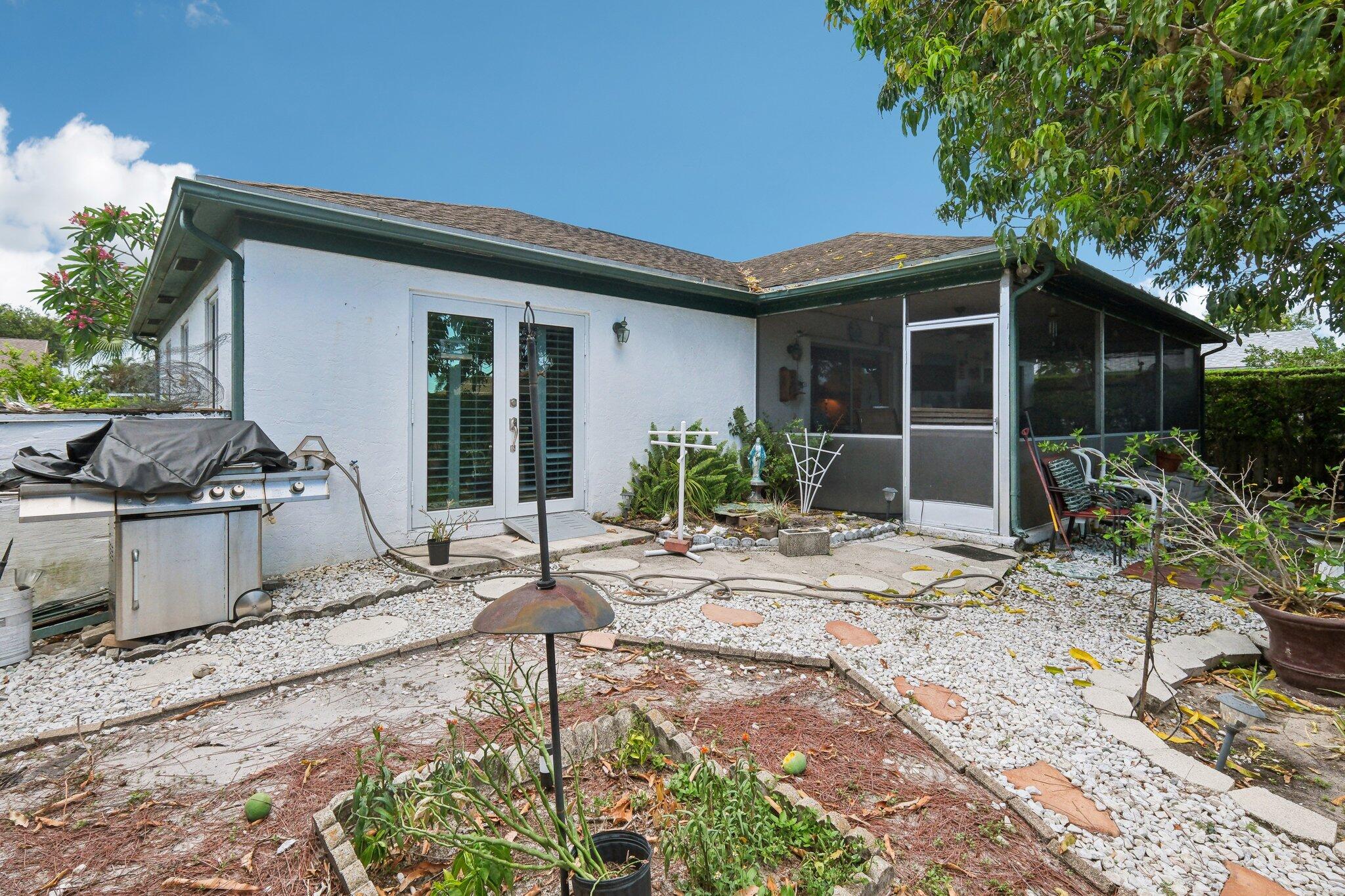 125 Wandering Trail, Unit TRL Jupiter, FL 33458 - Photo 20 of 22 a view of a house with backyard sitting area and porch