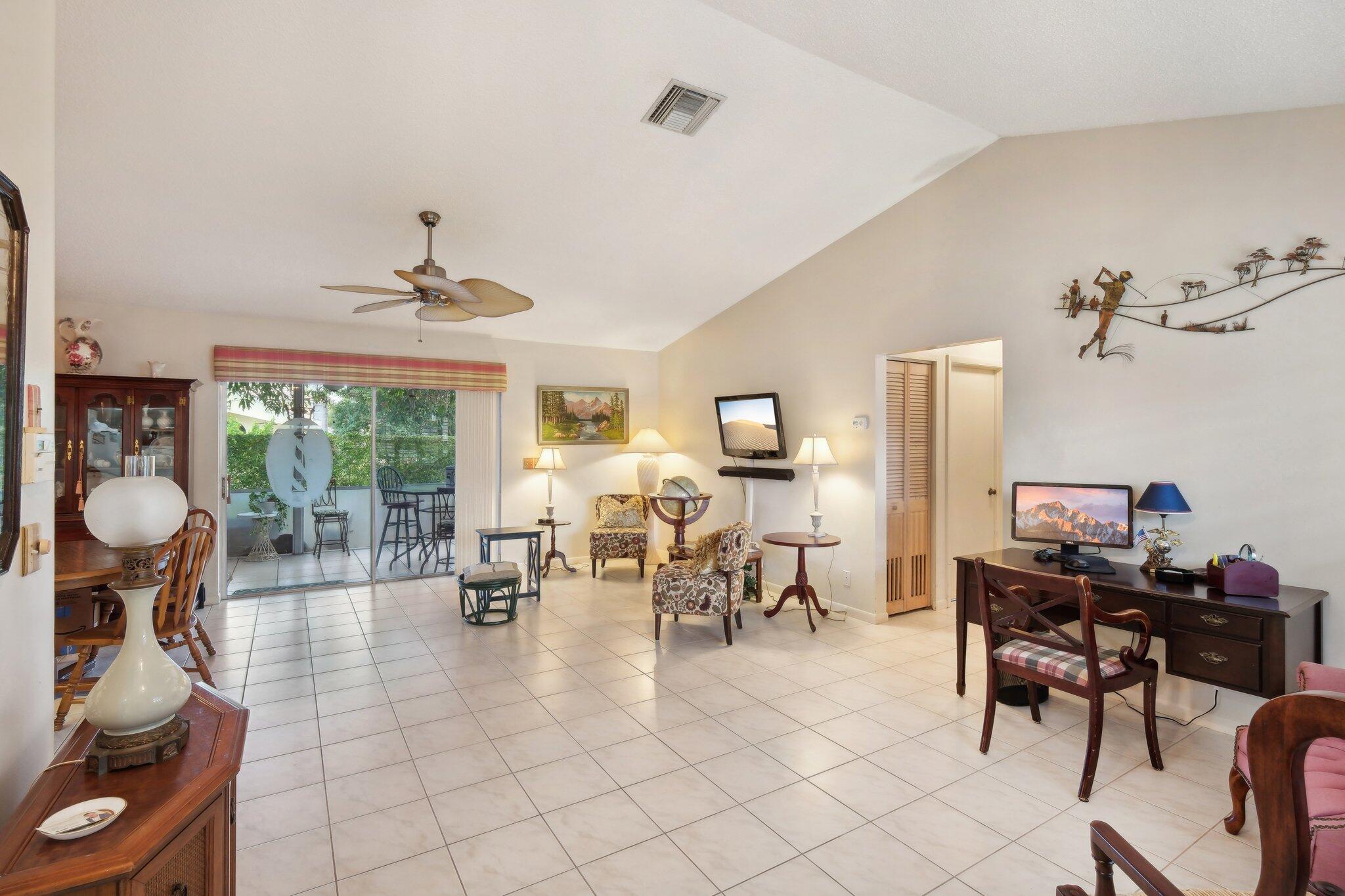 125 Wandering Trail, Unit TRL Jupiter, FL 33458 - Photo 8 of 22 a living room filled with furniture and a chandelier