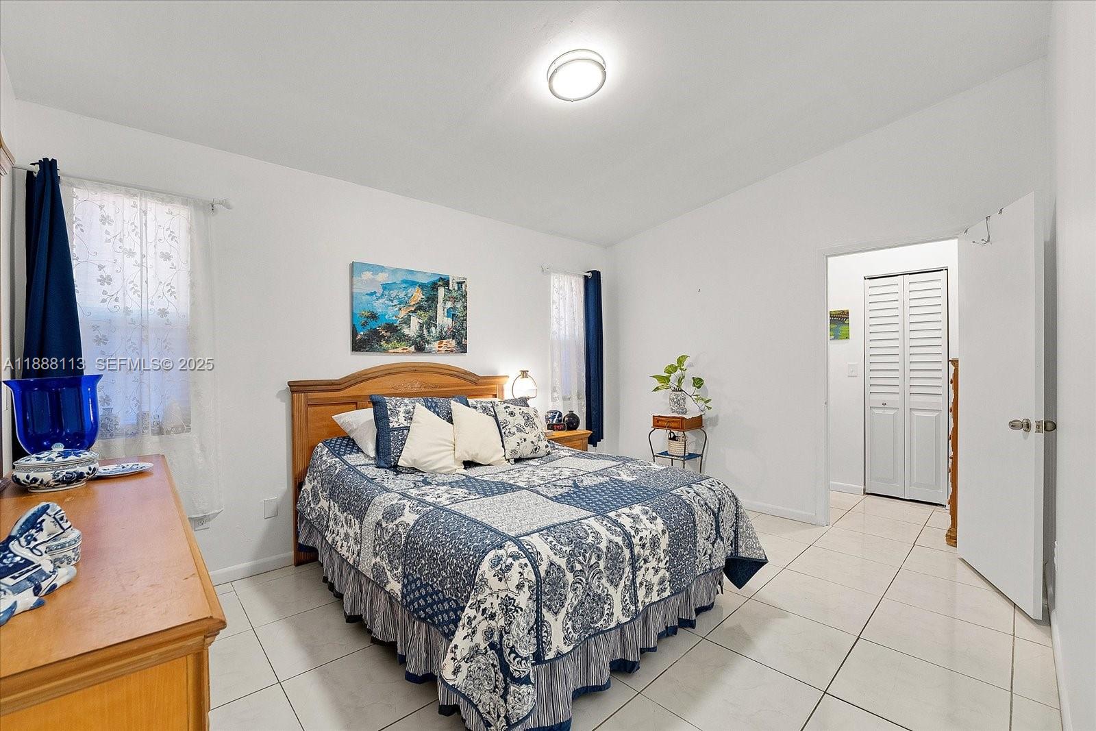 13556 Southwest 285th Terrace Homestead, FL 33033 - Photo 17 of 25 a bedroom with a bed and a night stand