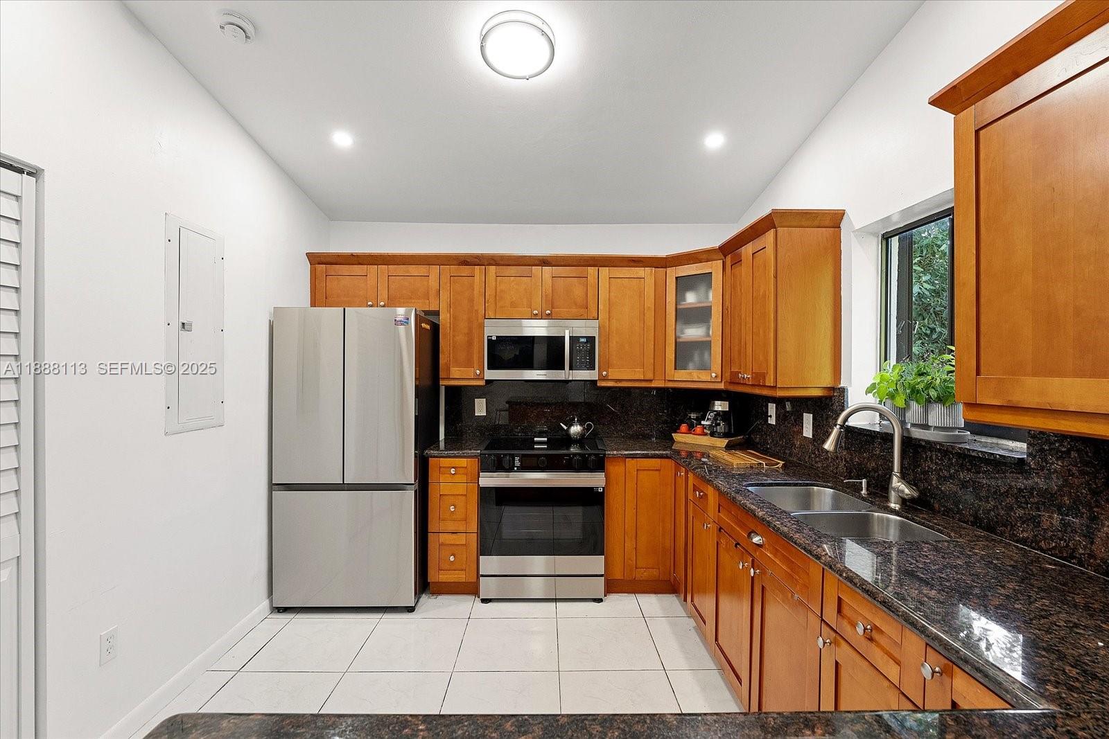 13556 Southwest 285th Terrace Homestead, FL 33033 - Photo 6 of 25 a kitchen with refrigerator a stove a sink and a microwave