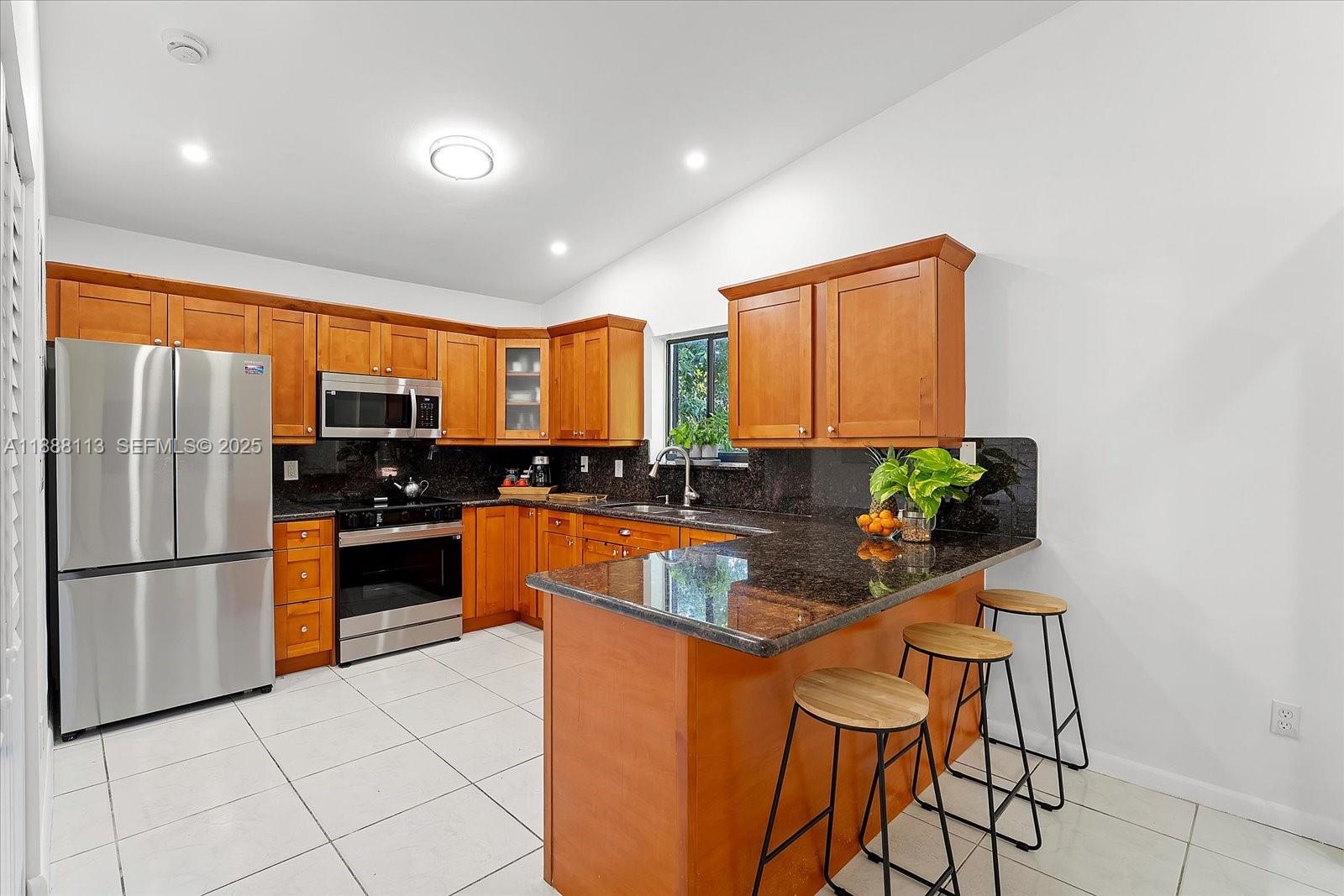 13556 Southwest 285th Terrace Homestead, FL 33033 - Photo 7 of 25 a kitchen with stainless steel appliances granite countertop a refrigerator a stove top oven and a sink