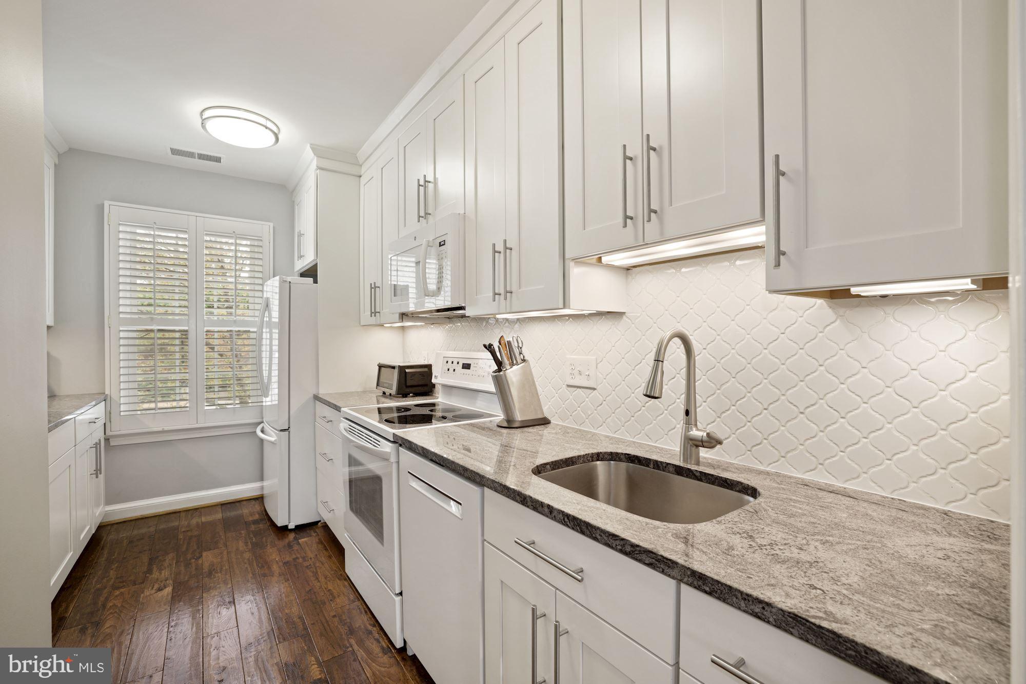 1650 Beekman Place Northwest, Unit A Washington, DC 20009 - Photo 6 of 25 Sleek all white kitchen w/42" cabinets