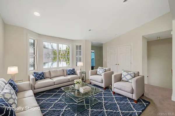 a living room with furniture a rug and a large window
