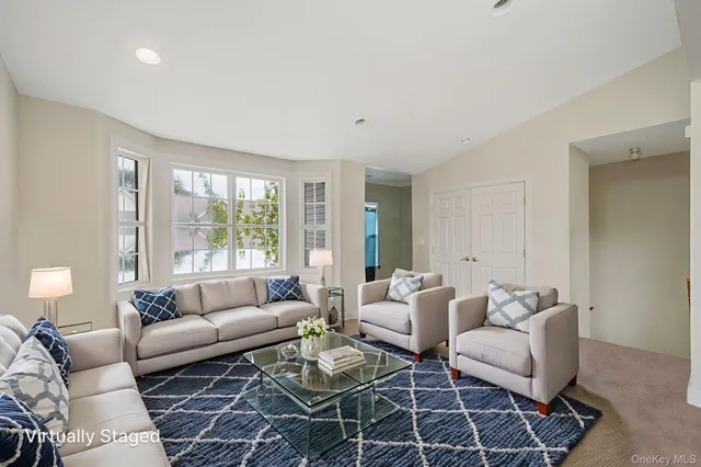 a living room with furniture a rug and a large window