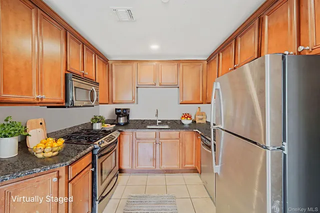 a kitchen with stainless steel appliances granite countertop a refrigerator stove sink and cabinets