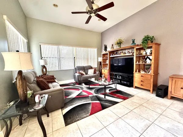 a living room with furniture a flat screen tv and a window