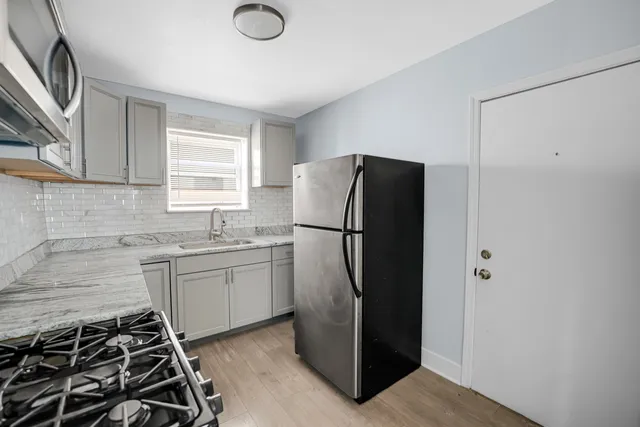 a kitchen with a refrigerator and a sink