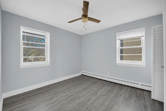 a view of a room with wooden floor and windows