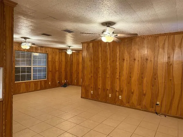 en empty room with windows and ceiling fan