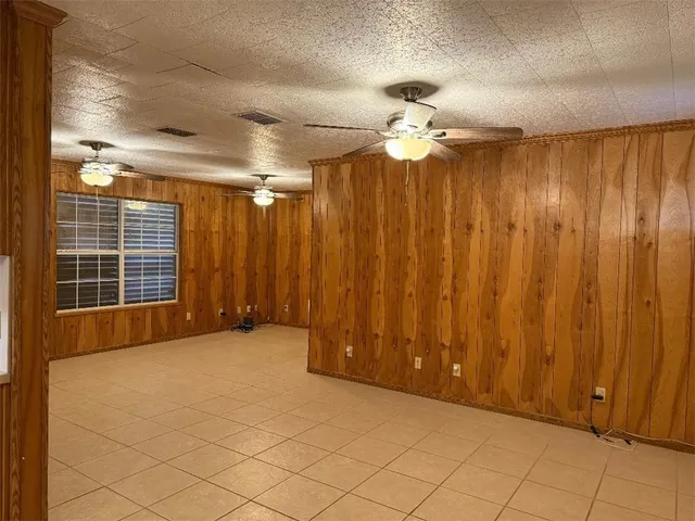 en empty room with windows and ceiling fan