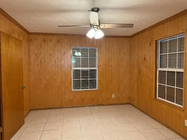 an empty room with windows and cabinet