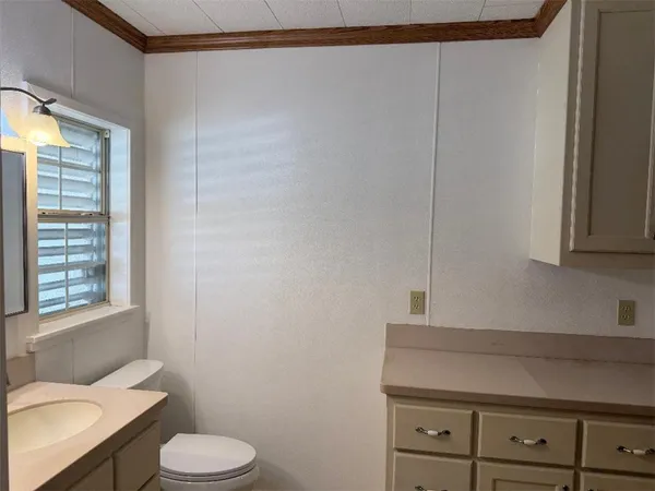 a bathroom with a toilet a sink and a window