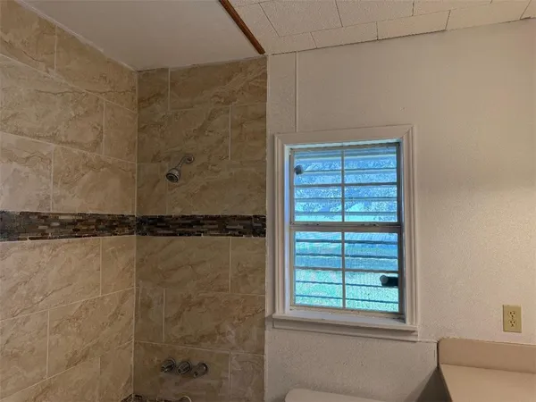 a bathroom with a window and a shower