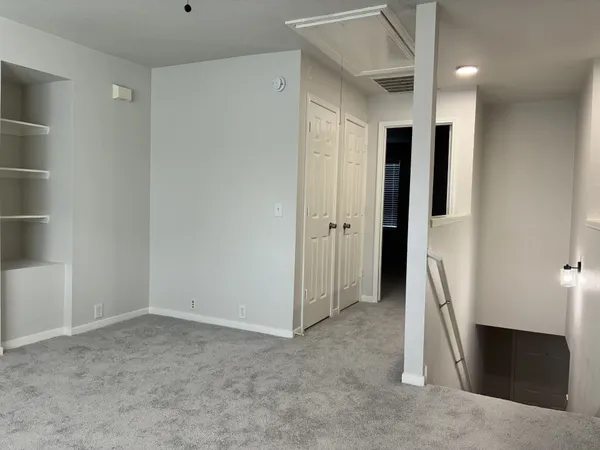 an empty room with a window and cabinet