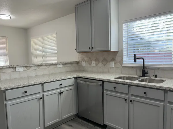 a kitchen with granite countertop cabinets stainless steel appliances and a counter space