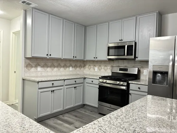 a kitchen with a sink cabinets and wooden floor