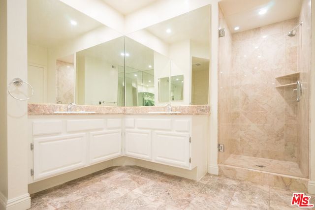 a bathroom with a shower a sink and a mirror