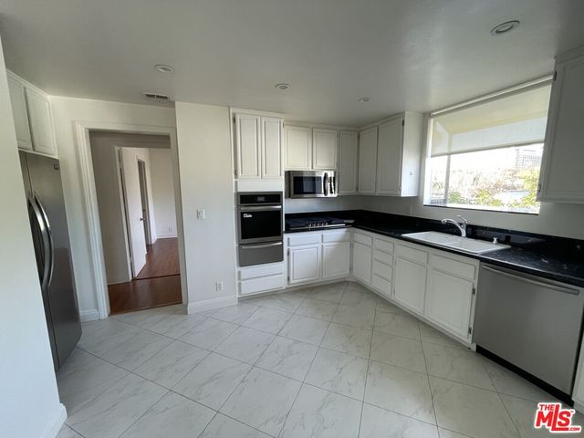 a large kitchen with a refrigerator and a sink