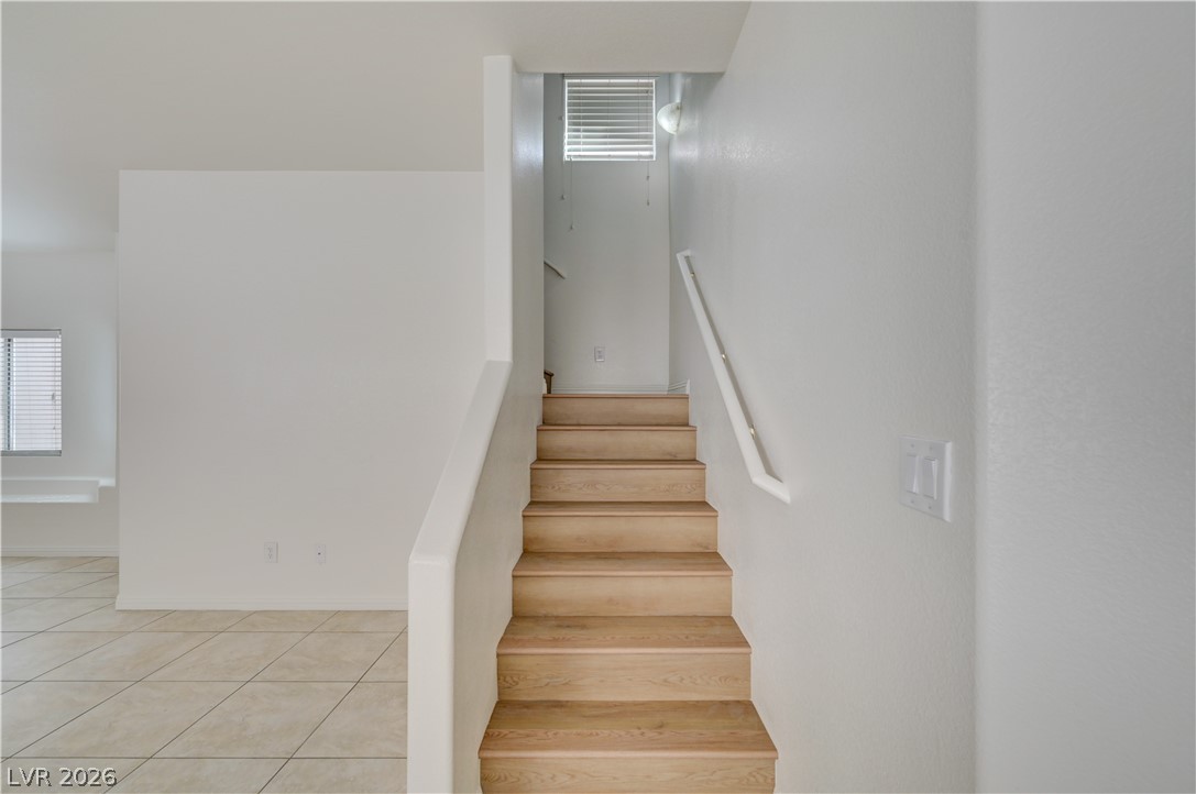 8918 Houston Ridge Avenue Las Vegas, NV 89178 - Photo 12 of 35 Blonde wood stairs lead to the upper level, while neutral-toned tile flooring covers the lower area.