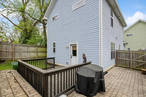 a view of a roof deck with couches chairs and wooden fence