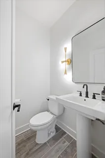 a bathroom with a toilet sink and mirror