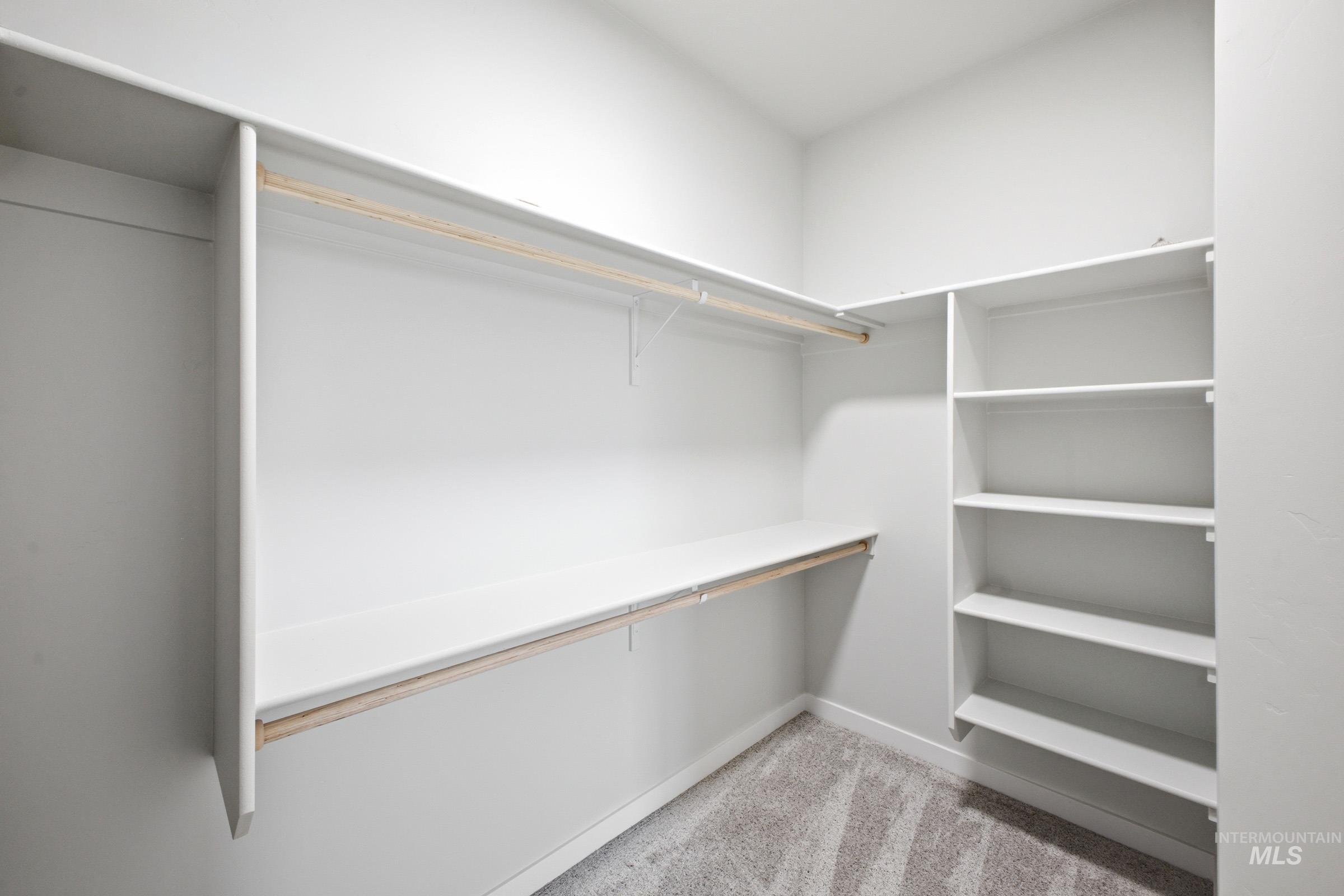 14104 Shiny Spruce Street Caldwell, ID 83607 - Photo 18 of 20 Spacious closet featuring built-in shelving, hanging rods, and neutral-toned carpeting
