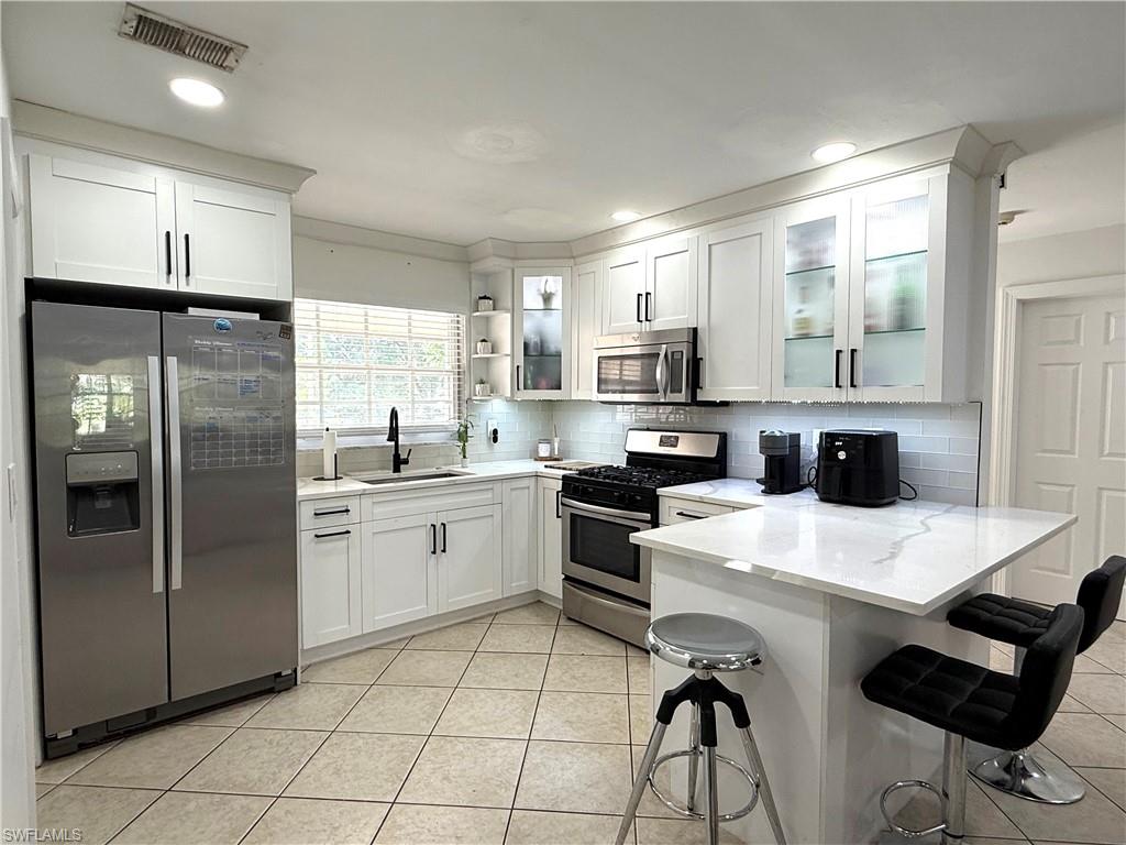 1964 42nd Street Southwest Naples, FL 34116 - Photo 10 of 25 a kitchen with appliances cabinets and a counter top space
