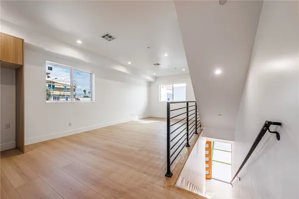 a view of a hallway with wooden floor and staircase
