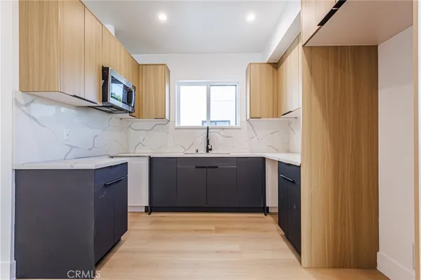 a kitchen with stainless steel appliances granite countertop a sink stove and microwave