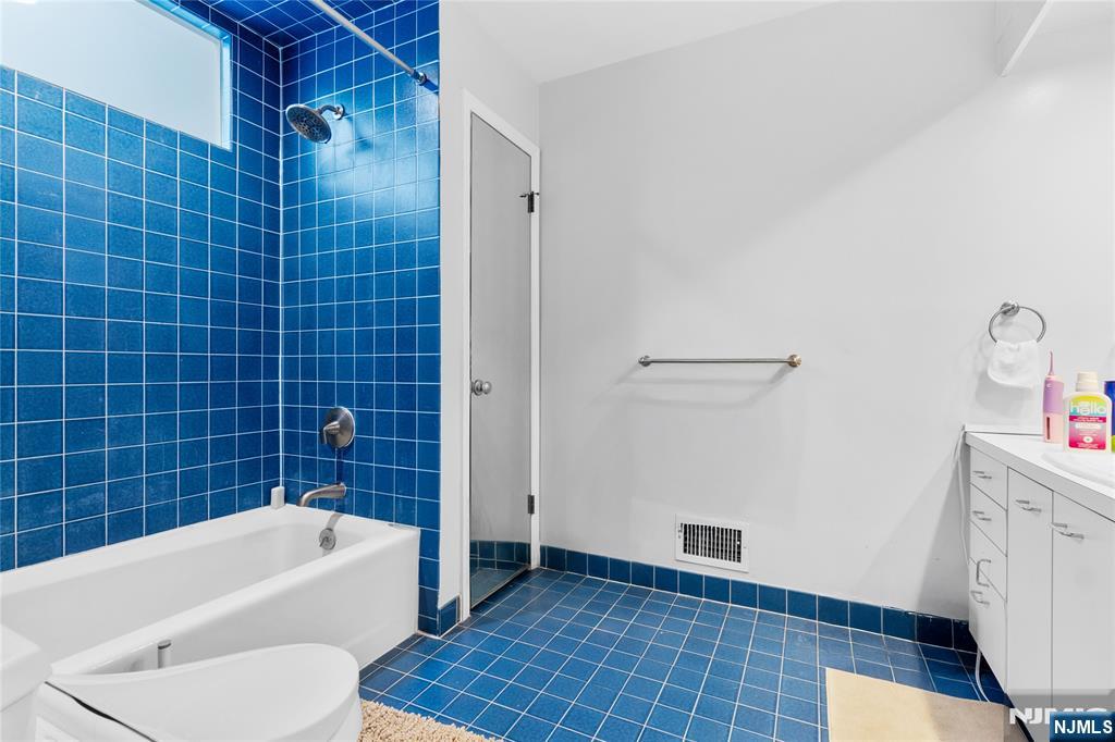 55 Hidden Ledge Road Englewood, NJ 07631 - Photo 14 of 22 a bathroom with a bathtub and a shower