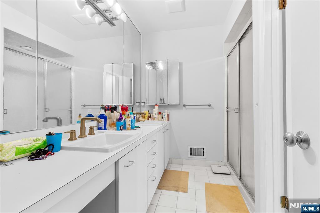 55 Hidden Ledge Road Englewood, NJ 07631 - Photo 15 of 22 a kitchen with a sink a faucet a chandelier and living room view