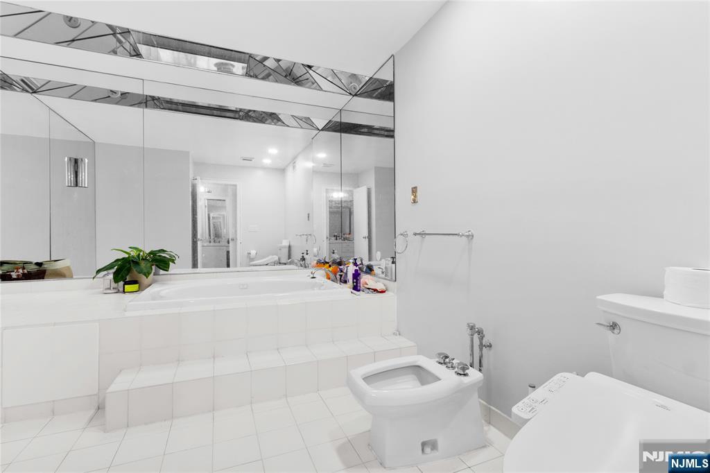 55 Hidden Ledge Road Englewood, NJ 07631 - Photo 16 of 22 a bathroom with a sink a toilet and shower