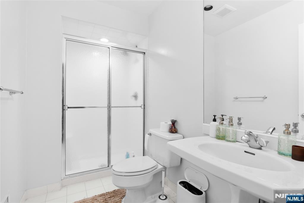 55 Hidden Ledge Road Englewood, NJ 07631 - Photo 8 of 22 a bathroom with a sink toilet and shower