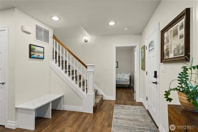 a view of a hallway with wooden floor and stairs
