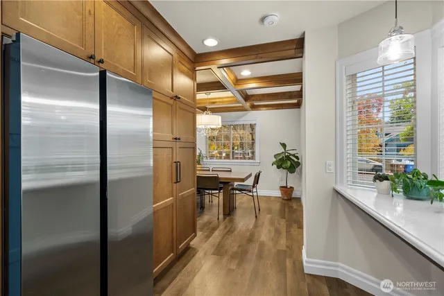 a kitchen with stainless steel appliances granite countertop a refrigerator and a wooden floor