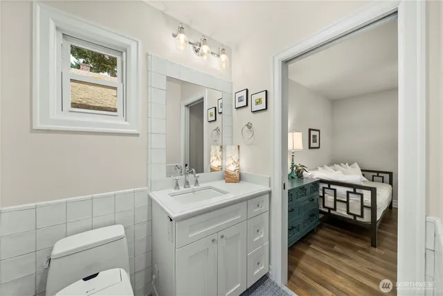 a en suite bathroom with a granite countertop sink and a mirror