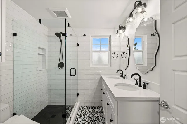 a bathroom with a sink a toilet and shower